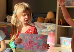 Dziewczynka prezentuje obrazek.