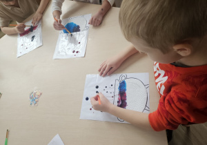 Dzieci stemplują na kartce papieru