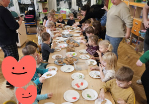 Dzieci dekorują pierniczki lukrem i posypkami