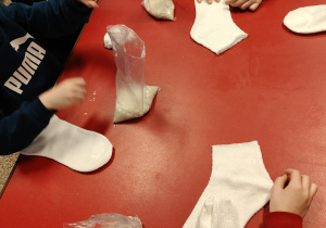 Dzieci wykonują bałwanka ze skarpety i ryżu