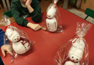 Dzieci wykonują bałwanka ze skarpety i ryżu