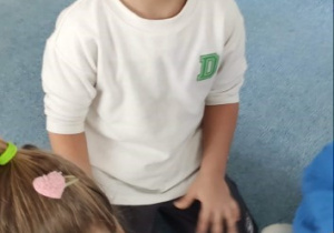 Chłopiec układa ulubione składniki na krążek pizzy