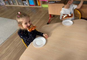 Dziewczynka je pizzę