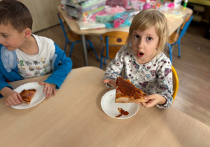 Dziewczynka trzyma w ręku pizzę