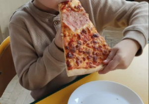 Chłopiec je pizzę