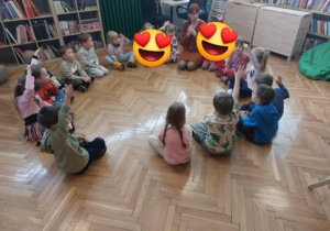Dzieci siedzą w kole i słuchają czytanej opowieści