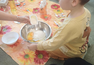 Chłopiec wkłąda serek do miski