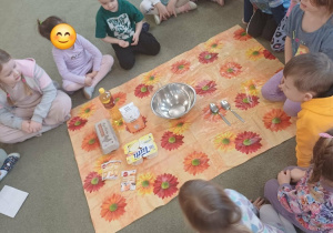 Dzieci przygotowują produkty niezbędne do wykonania pączków