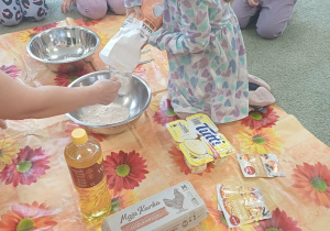 Dziewczynka wsypuje mąke do miski