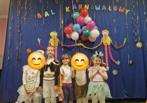 Dzieci w strojach na tle dekoracji na balu karnawałowym