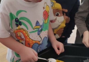 Chłopiec wsypuje sodę do wulkanu