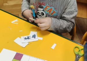 Chłopiec wycina obrazki do zadania z kodowaniem