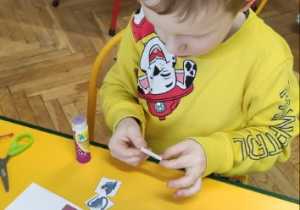 Chłopiec przykleja obrazki wg określonego kodu