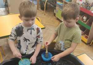 Dzieci mieszają ryż z farbą