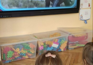 Dzieci oglądają film o dinozaurach