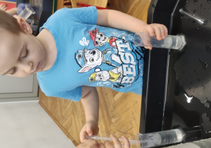 Dziecko przelewa wodę pipetą