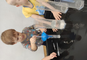 chłopiec przelewa wodę