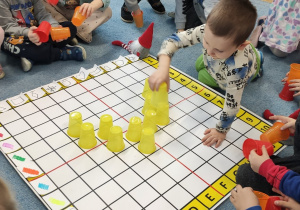 Dzieci układają kubeczki wg określonego kodu