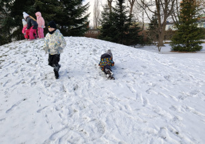 Dzieci turlają się z górki