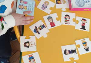 chlopiec ukłąda puzzle "Mieszkańcy świata"
