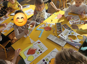 Dzieci pracują przy stolikach.
