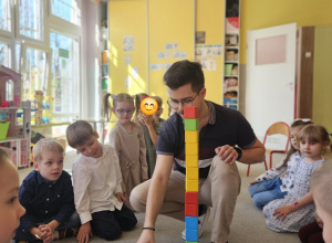 Dzieci budują wspólnie wieżę z klocków