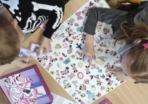 Dzieci siedzą przy stoliku grają w wyszukiwankę